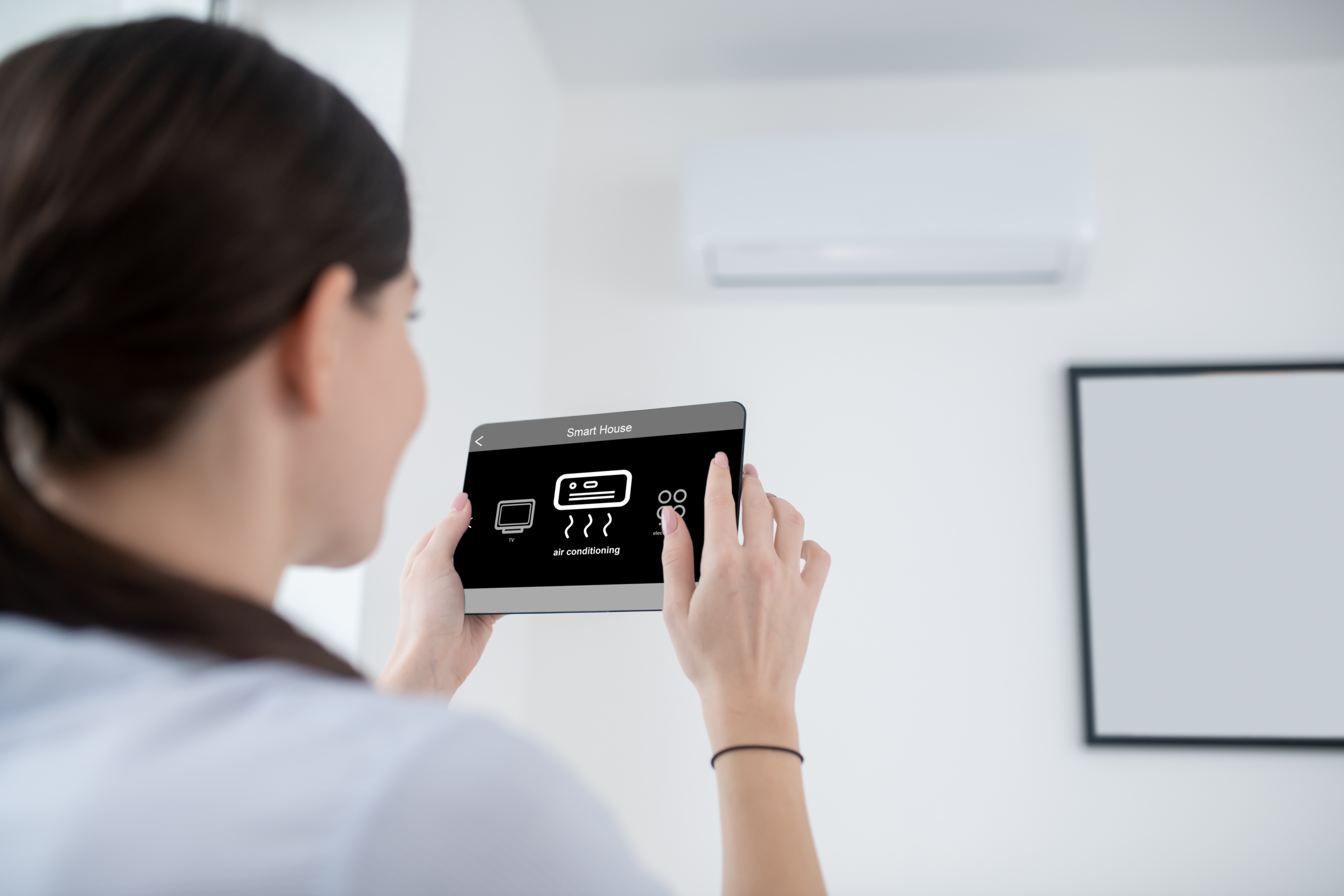 Woman turning on an air conditioning unit